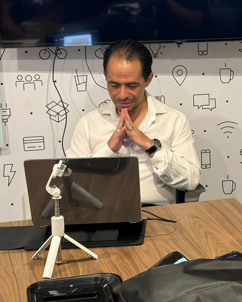 Salvador Villarreal escuchando, con las manos juntas, frente a la laptop durante la grabación de una sesión de la Mesa Ejecutiva.