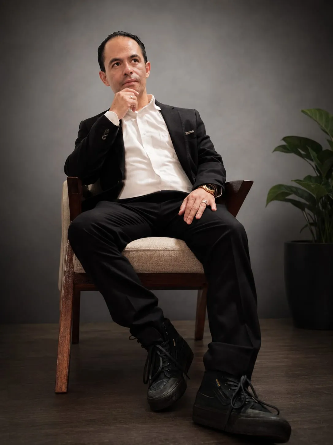 Retrato editorial de Salvador Villarreal sentado, en saco negro y camisa blanca, sobre un fondo de estudio.